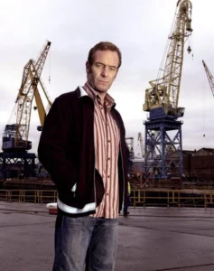 Michael standing on the quayside with mechanical cranes in the background